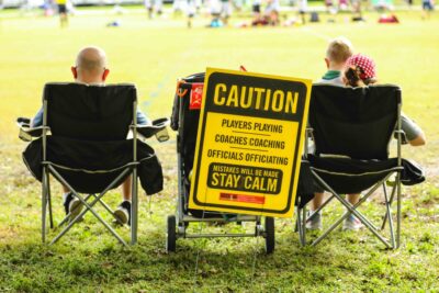 People sitting in chairs with stay calm sign